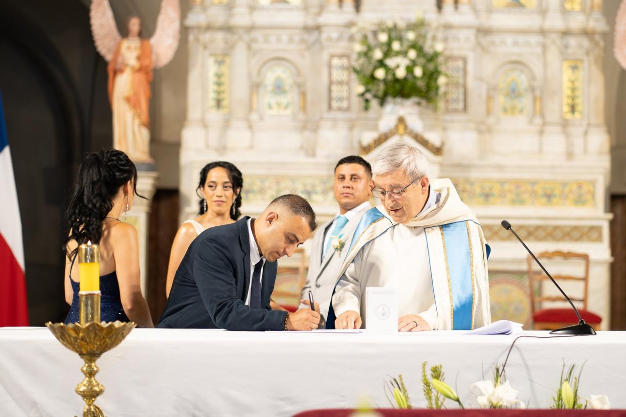 padrino de matrimonio que firma en la iglesia delante del cura