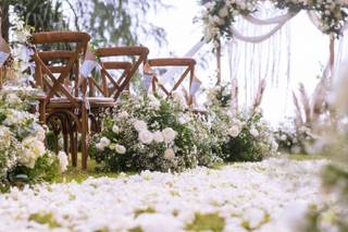 pétalos blancos en el pasto y sillas de madera