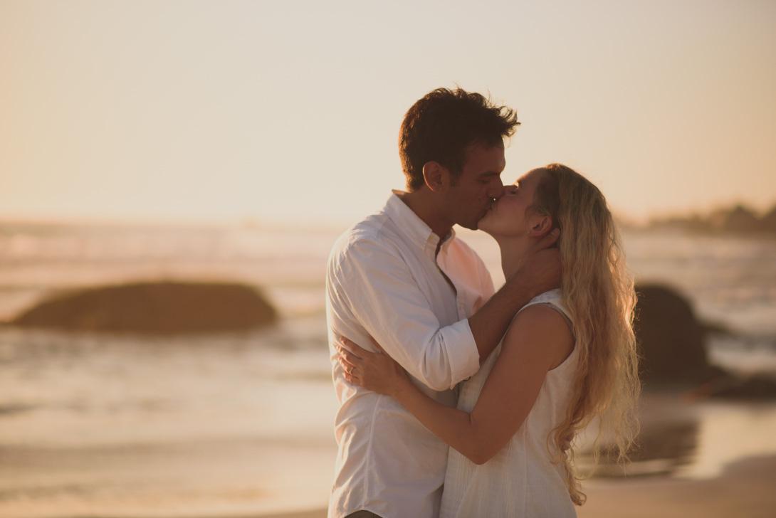 pareja se besa con el mar de fondo