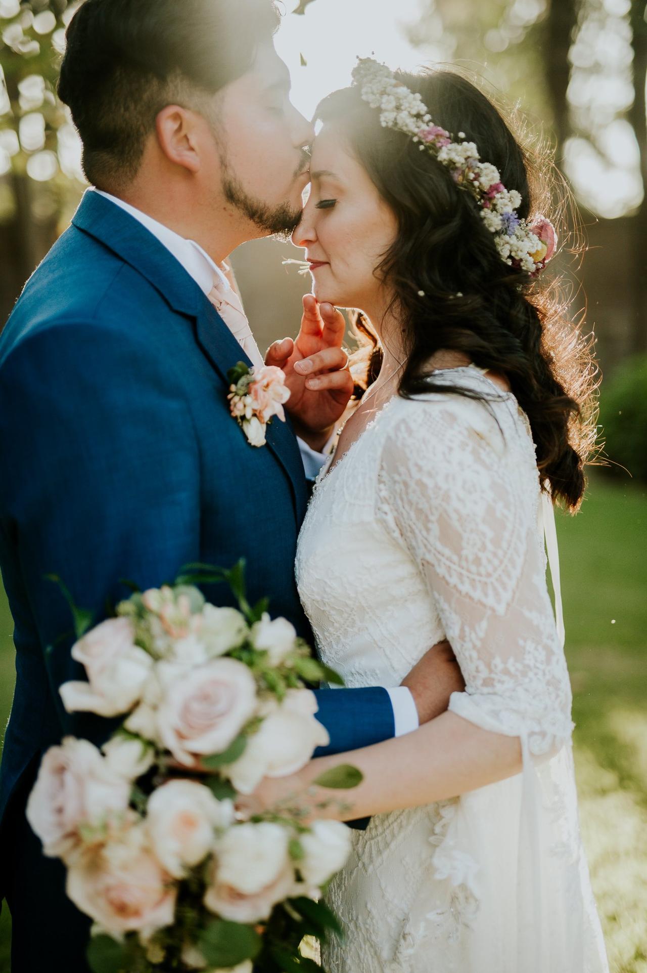 novio besa en la frente a la novia