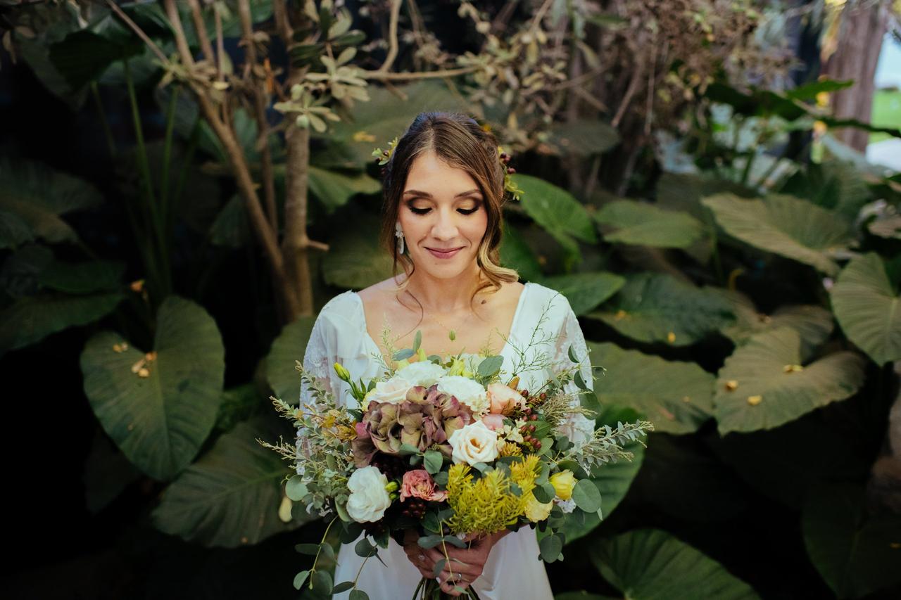 novia con un vestido escote V, un gran ramo de novias y un peinado recogido