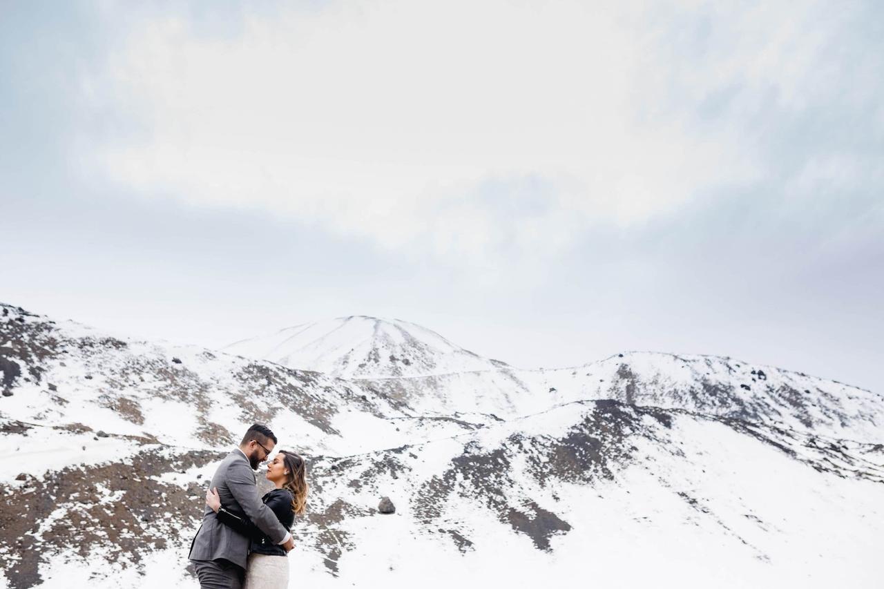 pareja abrazada en montañas nevadas