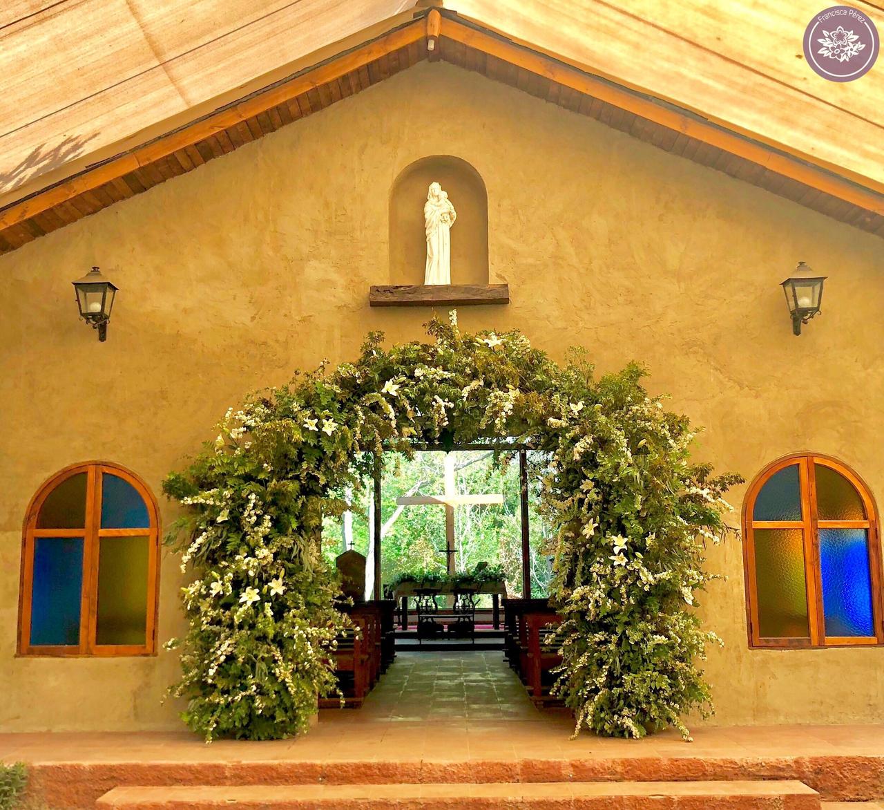 Arco de flores y plantas de una iglesia