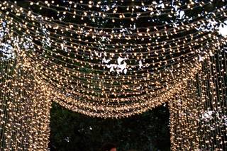 pareja sentada en una mesa con velas y guirnaldas de luces