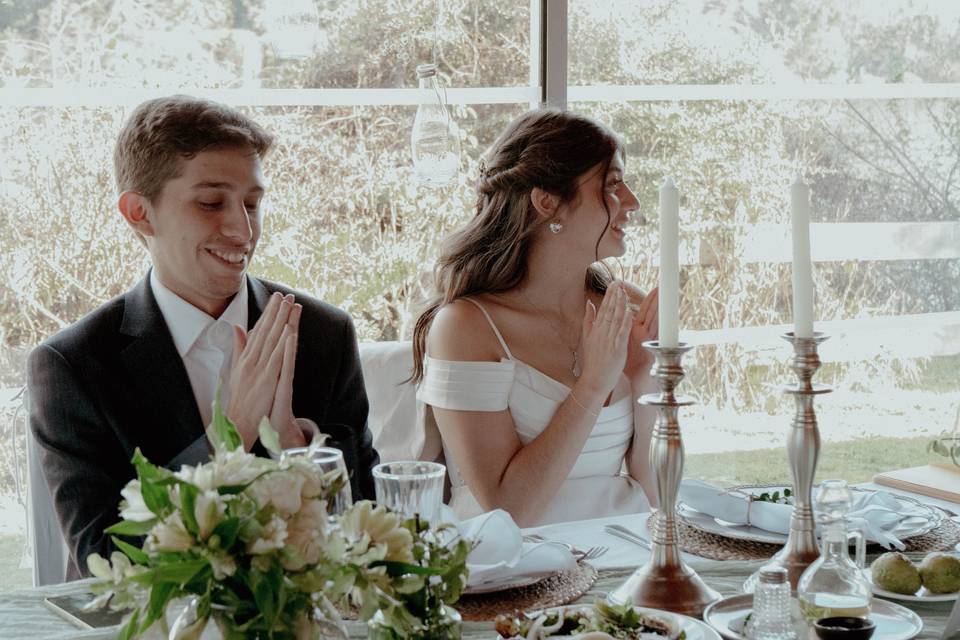 Pareja sentada en su mesa de novios