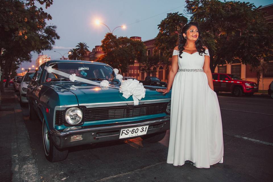 Novia posando frente a un auto azul