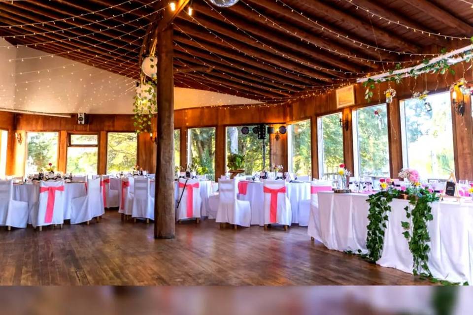 Salón de madera con mesas montadas