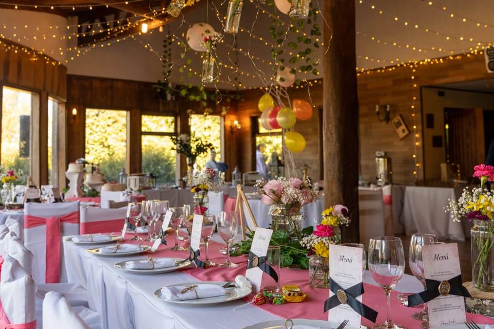 Mesa con mantel blanco y rosa