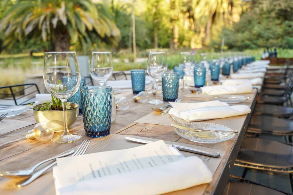 Mesa con copas de cristal y vasos azules