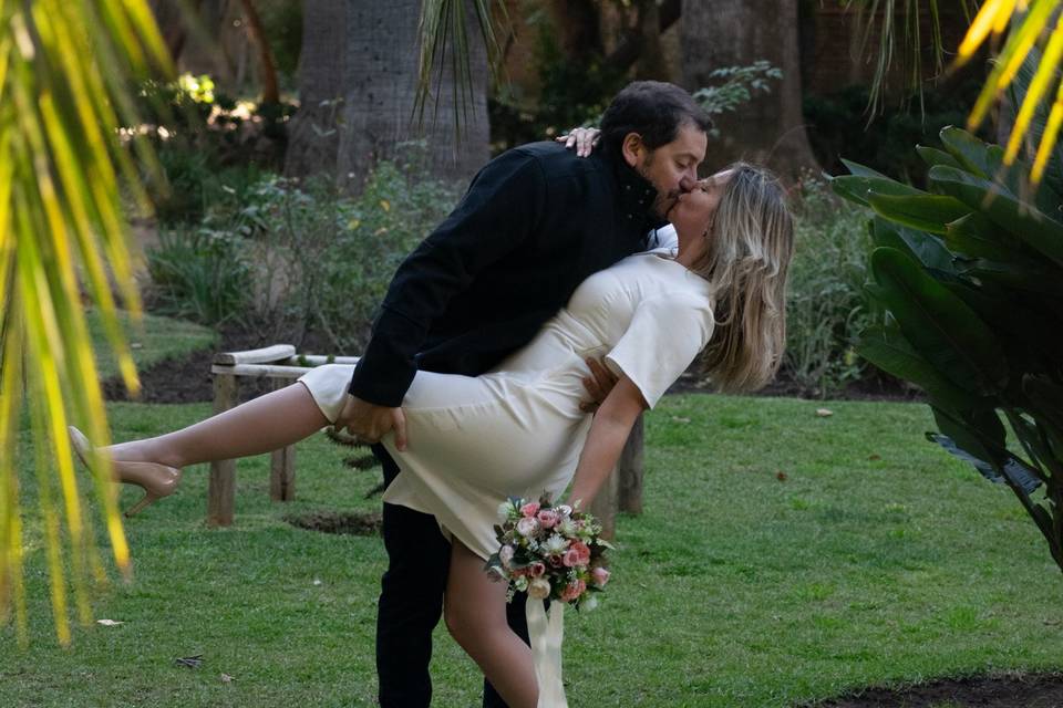 Novios dándose un beso en el jardín