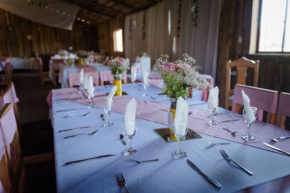 Mesa con mantel blanco y rosa