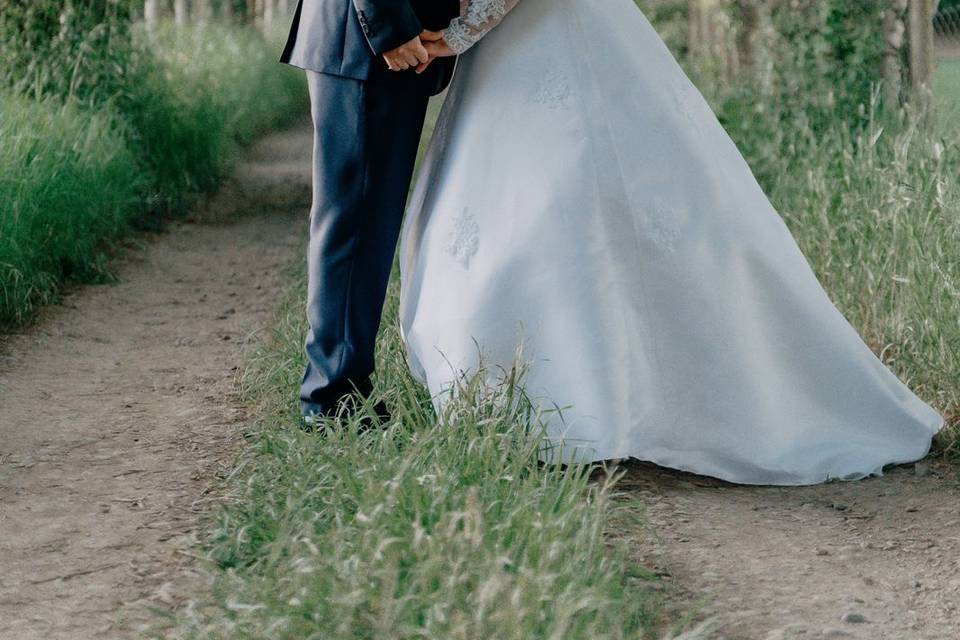 Novios dándose un beso en un camino