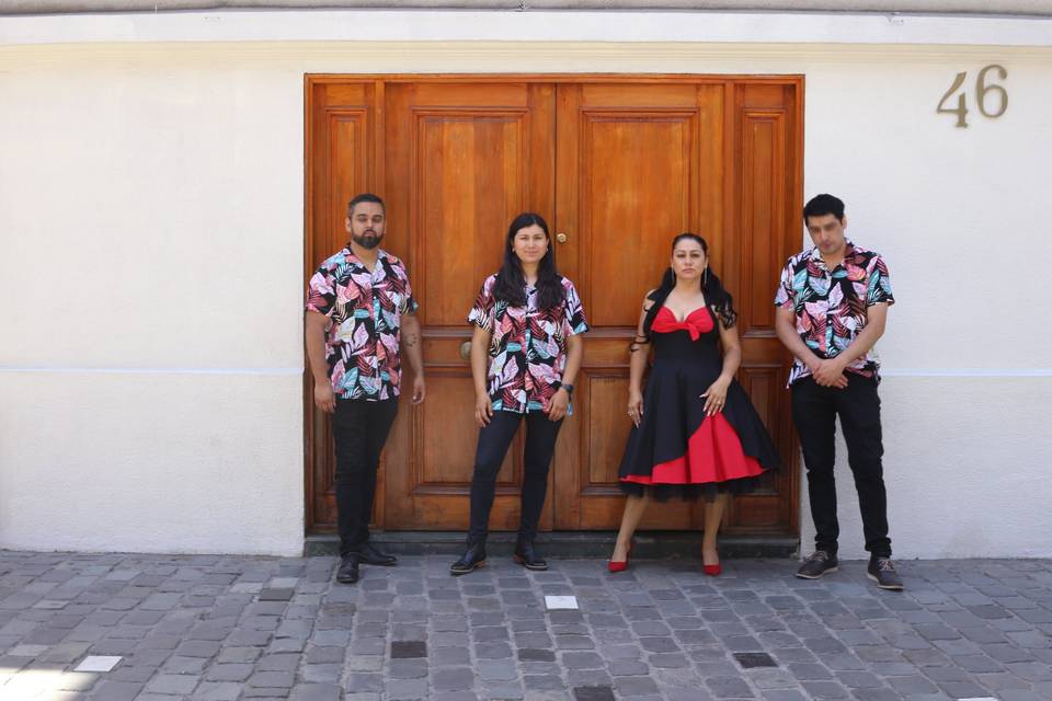 Músicos posando frente a una puerta