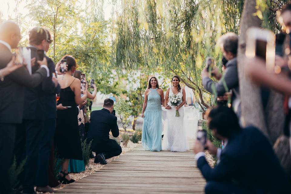 Novia caminando del brazo de una mujer