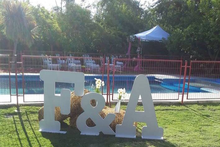 Letras gigantes blancas en el jardín