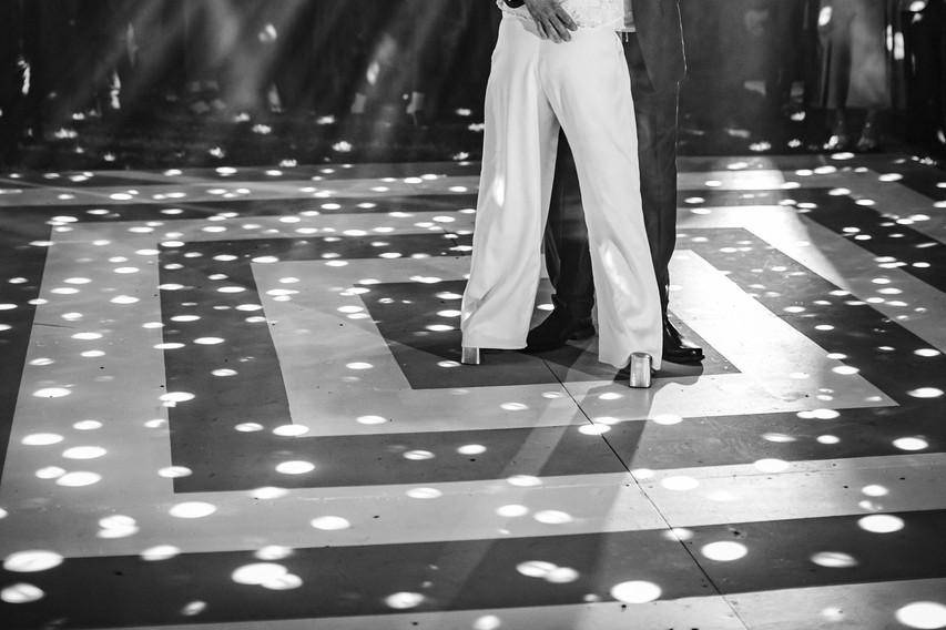 Novios bailando en la pista iluminada con bola disco