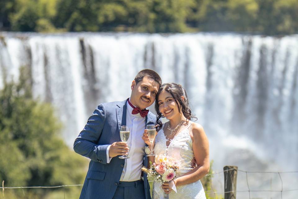 Novios posando frente a una cascada