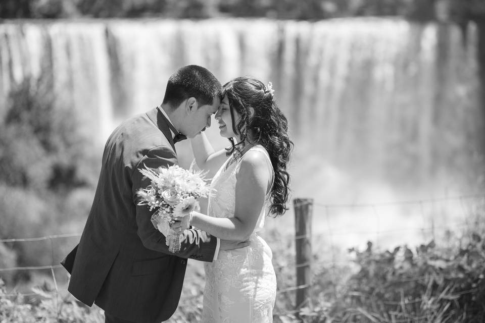 Novios posando frente a una cascada