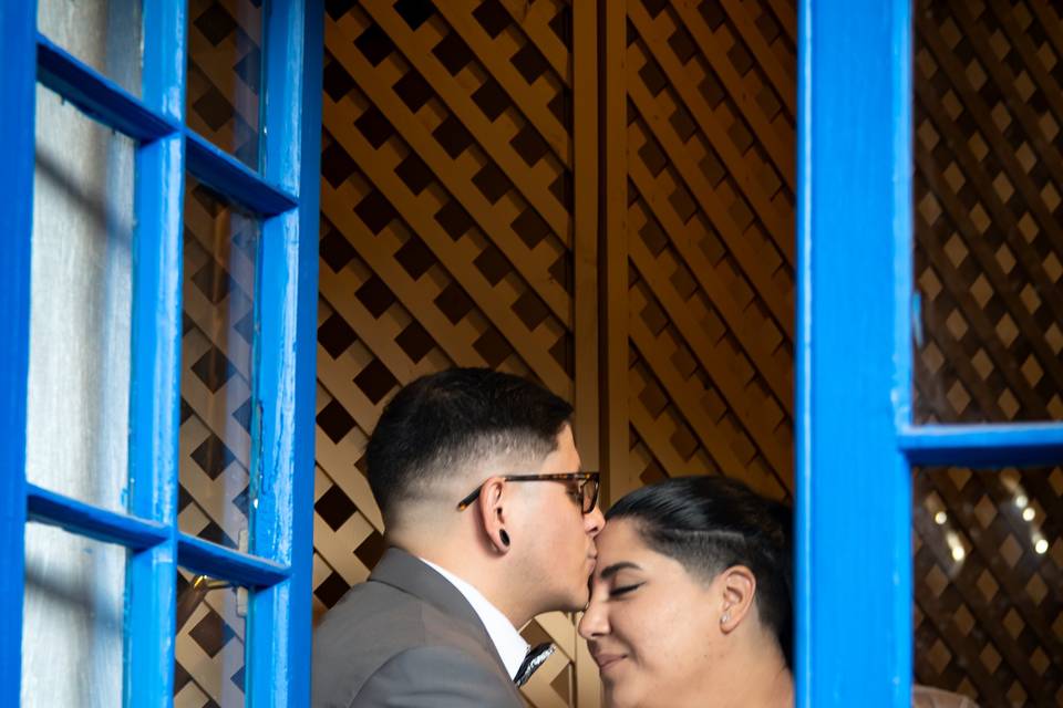 Novio dándole un beso a la novia frente a la ventana