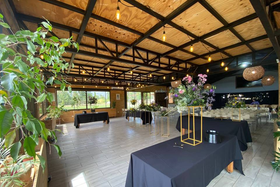 Salón con techo de madera y ventanas grandes