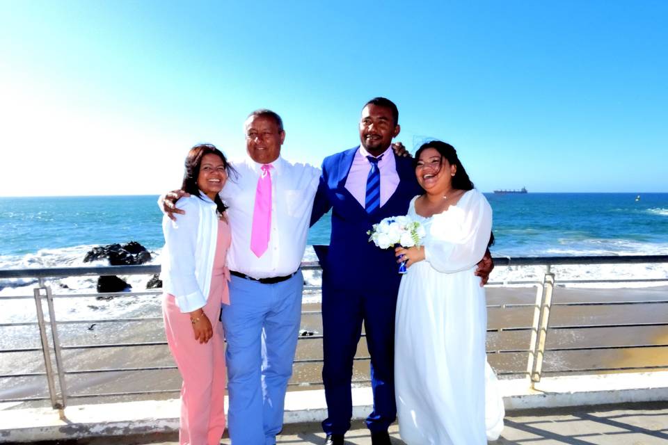 Novios con invitados frente a la playa