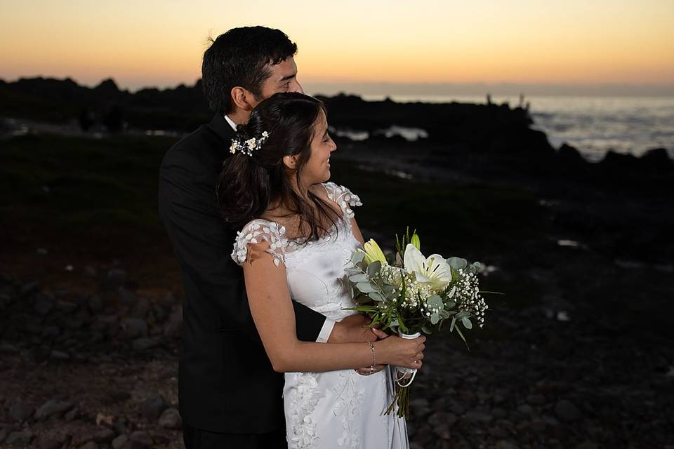 Pareja abrazada mirando el atardecer