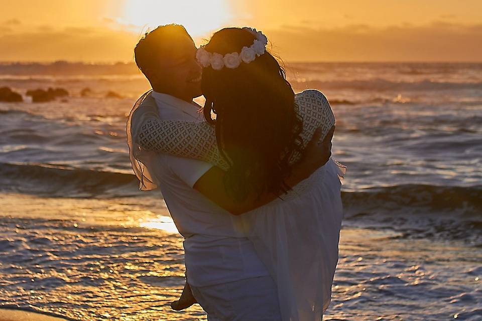 Novio cargando a la novia en el mar