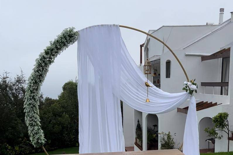 Arco con flores y tela blanca