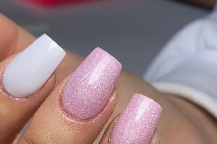 Uñas acrílicas en tono rosa y blanco con micro glitter