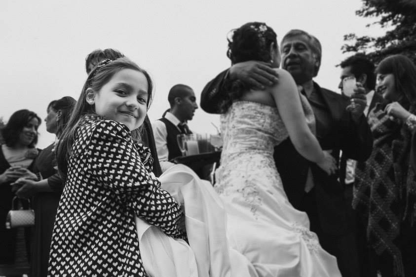 Niña sosteniendo la cola del vestido de la novia