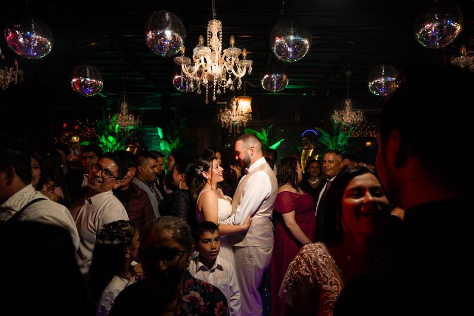 Novios bailando en el centro de la pista rodeados de sus invitados